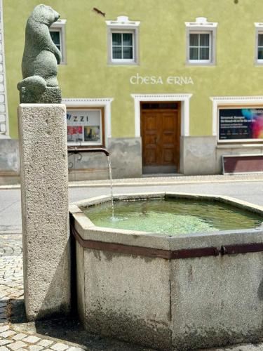 a fountain in the middle of a street with a building at Cozy Lodge in Bivio 20 Minutes from St Moritz in Bivio