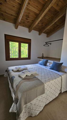 a large bedroom with a large bed with blue pillows at Hostel Raíces in La Matea