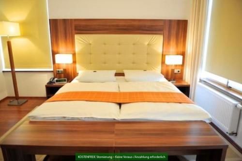 a large bed in a room with two lamps at Akzent Hotel Tietmeyer & Cross Side in Schöppingen