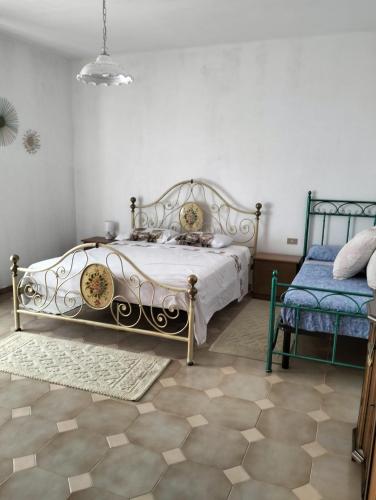 a bedroom with a bed and a blue chair at Chiaro di Luna in Budoni