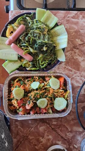 two trays of food sitting on a table with food at Manan Guesthouse in Chʼkalovka