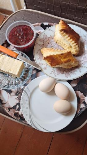 a table with two plates of cake and eggs at Manan Guesthouse in Chʼkalovka