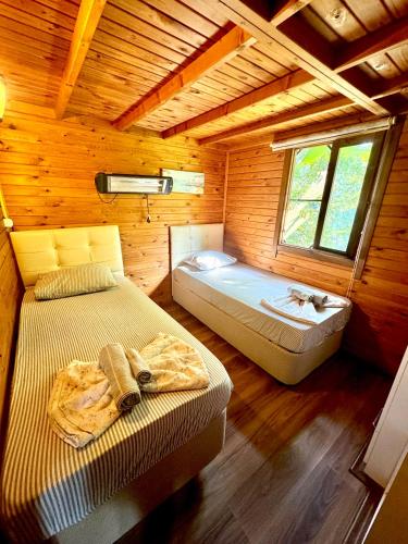 a bedroom with two beds in a wooden cabin at Villa Balım in Koycegiz
