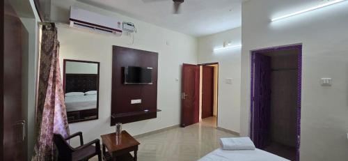 a bedroom with a bed and a tv on the wall at Hotel AMR Residency in Golden Rock