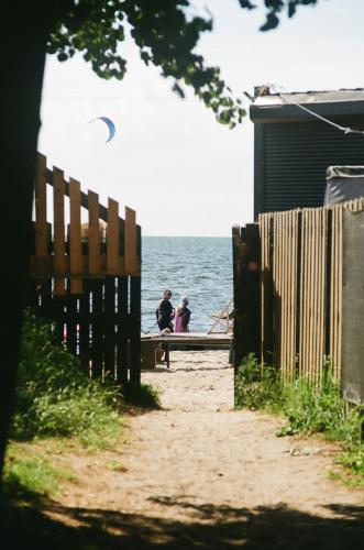 two people sitting on a bench next to the ocean at Sonata Camp in Jastarnia