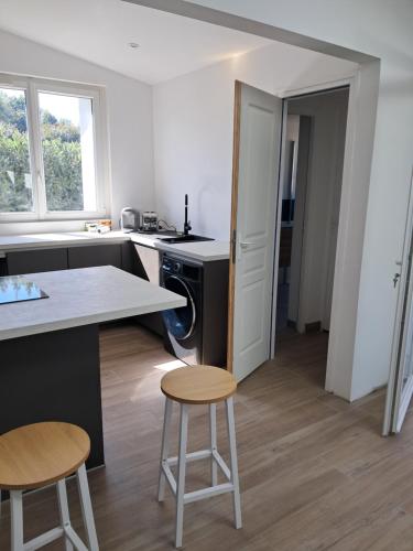a kitchen with a counter and two stools in it at l'annexe in Le Givre