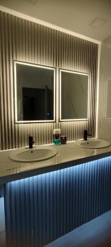 a bathroom with two sinks and two mirrors at CulturaHumana Guesthouse in Panama City