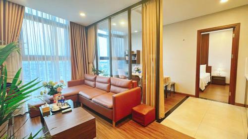 a living room with a leather couch in a room at Homestay Apec Mandala Hotel & Suites Hai Duong in Hải Dương