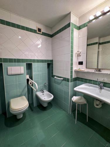 a bathroom with a sink and a toilet and a mirror at Euro Hotel in Nuoro