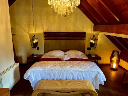 a bedroom with a bed and a chandelier at WoodStone Hotel Fazenda in Gramado