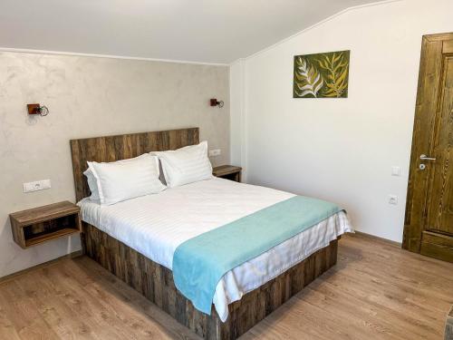 a bedroom with a large bed with a wooden headboard at Vila Intre Lacuri in Sovata