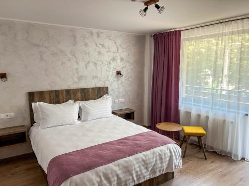 a bedroom with a large bed and a window at Vila Intre Lacuri in Sovata
