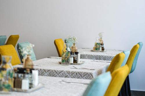 a table with yellow chairs and a table with tablesearcher at Vila Intre Lacuri in Sovata