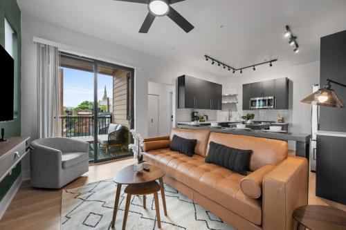 un soggiorno con divano e cucina di PFR Suites - Highland, 3BR 2BA Shadyside Condo, Penthouse Unit, 2 Decks, Off-Street Parking, 4th Floor Walkup a Pittsburgh