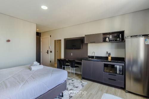 a hotel room with a bed and a kitchen at TCO - Apartamentos no Centro Histórico Porto Alegre/RS in Porto Alegre