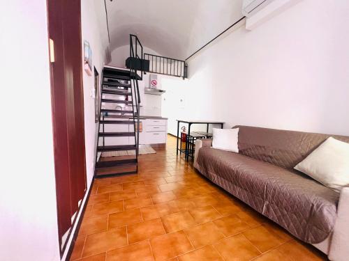 a living room with a couch and a staircase at Suite Brescia 10 - Sanremo in Sanremo