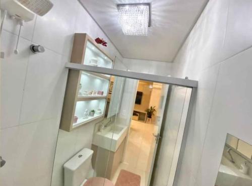 a bathroom with a toilet and a sink and a mirror at Apartamento centro de Belém cop30 in Belém