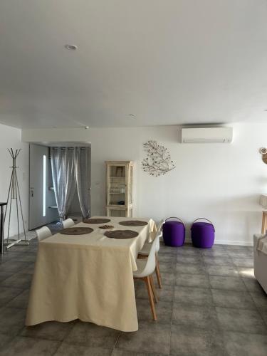 una stanza bianca con un tavolo e alcune sedie di Maison avec jardin en Provence a Oraison
