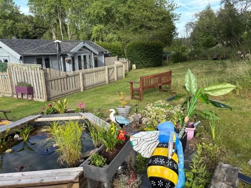 a garden with a pond with a boat in it at Daisy Cabin in Kincardine OʼNeil