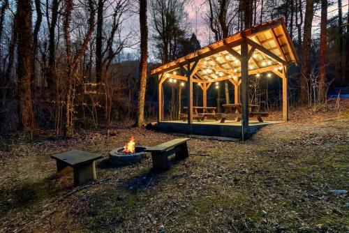 a picnic shelter with benches and a fire in a field at Serene Retreat Hot Tub, Fire Pit, Arcade Fun in Townsend