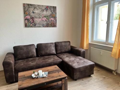 a living room with a leather couch and a coffee table at Gegenüber vom Theater in Gera