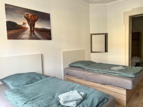 a bedroom with two beds and a picture of an elephant at Gegenüber vom Theater in Gera