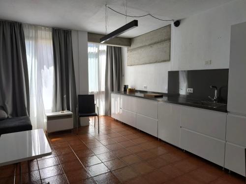 プラヤ・デ・サンティアゴにあるRolin Apartmentの白いキャビネットと大きな窓のあるキッチン