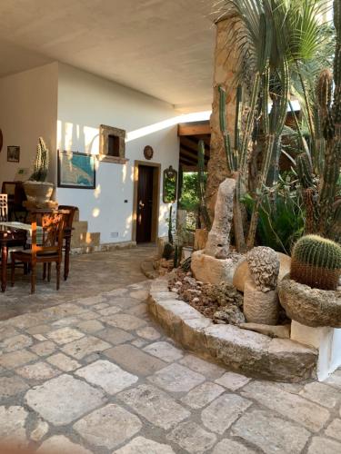 a patio with a table and chairs and cactus at Felline In Bed&Breakfast Dimora di Charme el Salento in Felline