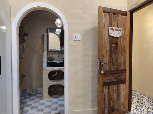 a bathroom with an open door and a sink at Nắng Vĩnh Hy in Ninh Hải