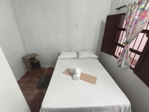 a small room with a bed with a towel on it at Makarius in Santa Fe de Antioquia