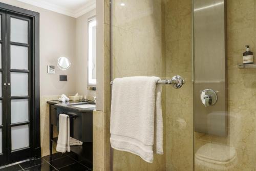 a bathroom with a shower with a towel and a sink at Casa Lucia Member of Melia Collection in Buenos Aires