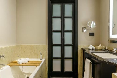 a bathroom with a bath tub and a sink at Casa Lucia Member of Melia Collection in Buenos Aires