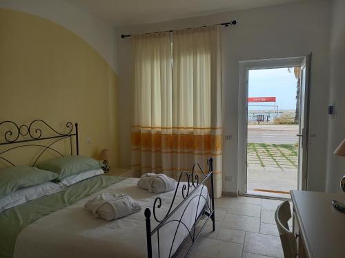 a bedroom with a bed and a large window at Il Canto del Mare Rooms & Suites in Porto SantʼElpidio