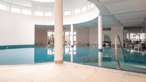 a swimming pool in a building with a pool at Colombi Hotel in Freiburg im Breisgau