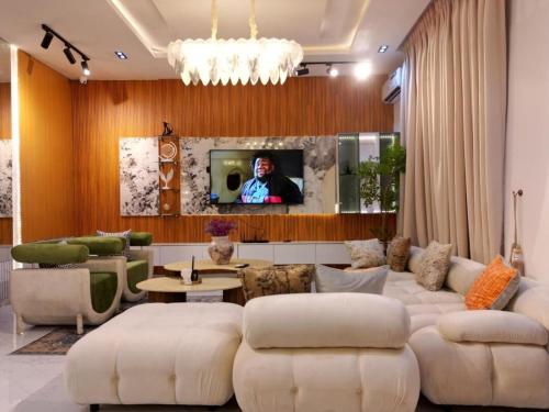 a living room with white furniture and a tv at Home Away from home in Ikota