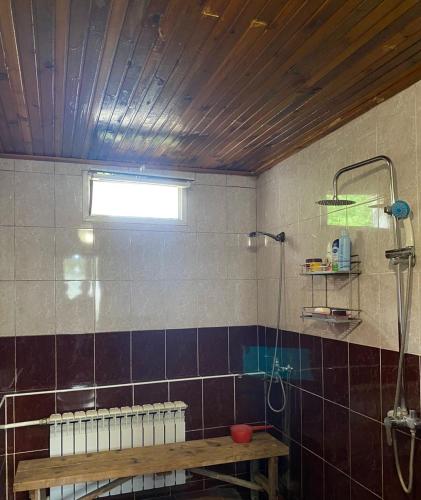 a bathroom with a shower and a wooden table at Talas guest house in Talas
