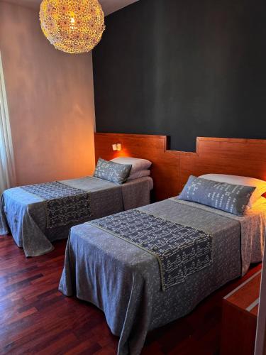 a bedroom with two beds and a chandelier at Euro Hotel in Nuoro