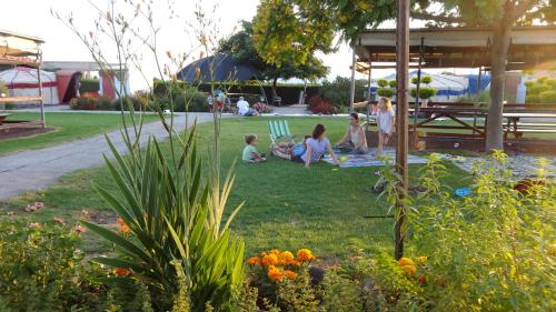 a group of people sitting on the grass in a park at Sea of Galilee - Genghis Khan in The Golan in Giv'at Yo'av