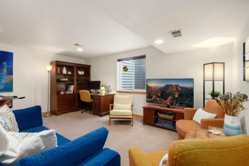 a living room with a blue couch and a tv at Rigden Retreat Garage, Dog Friendly, Near Trails in Fort Collins