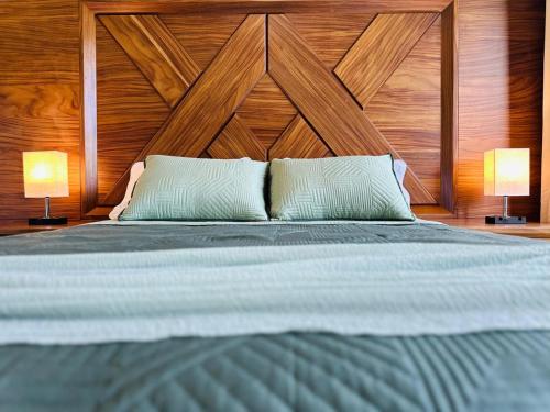 a bedroom with a large bed with two lamps at Jungle Guardian - Rooftop Pool & Beach Club in Zona Hotelera Tulum in Tulum