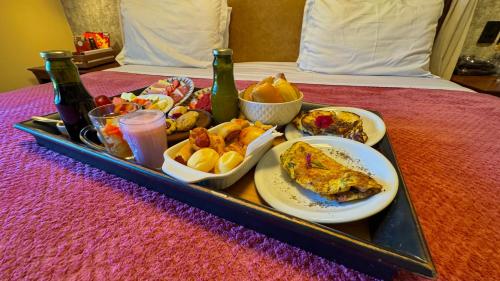 a tray of breakfast foods and drinks on a bed at WoodStone Hotel Fazenda in Gramado