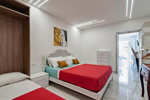 a bedroom with a bed with a red blanket at Balcone Caboto in Torre Lapillo
