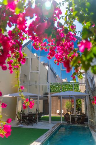 a building with a swimming pool and pink flowers at Ocean Porto - Beach House in Matosinhos
