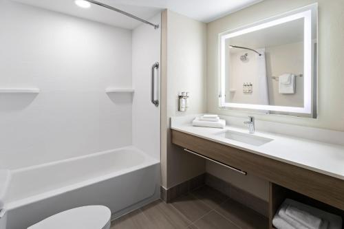 a bathroom with a sink and a tub and a toilet at Holiday Inn Express Augusta Downtown by IHG in Augusta