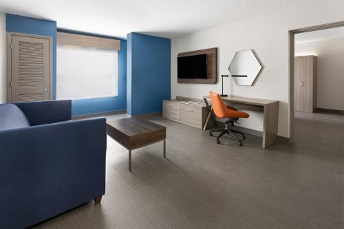 a room with a bed and a desk with a television at Holiday Inn Express Augusta Downtown by IHG in Augusta