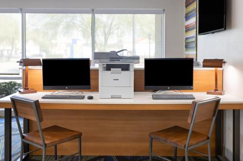 two computer monitors sitting on a desk with a printer at Holiday Inn Express Augusta Downtown by IHG in Augusta