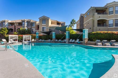 ein großer Pool mit Stühlen und Gebäuden in der Unterkunft Boulevard Stays 2BR by Stadium Pool Parking Gym 10 in Glendale