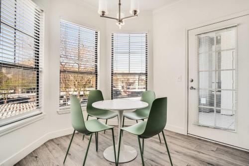ein Esszimmer mit Tisch und Stühlen und Fenstern in der Unterkunft Boulevard Stays 2BR by Stadium Pool Parking Gym 10 in Glendale