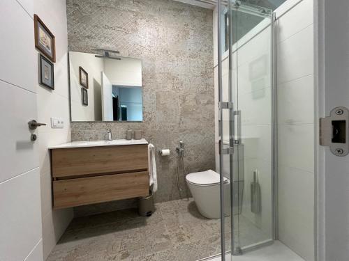 a bathroom with a sink and a toilet and a mirror at A CASIÑA dos LARANXOS in Cenlle