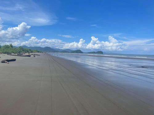 a sandy beach with waves in the ocean at Villa Inesita in Panguí